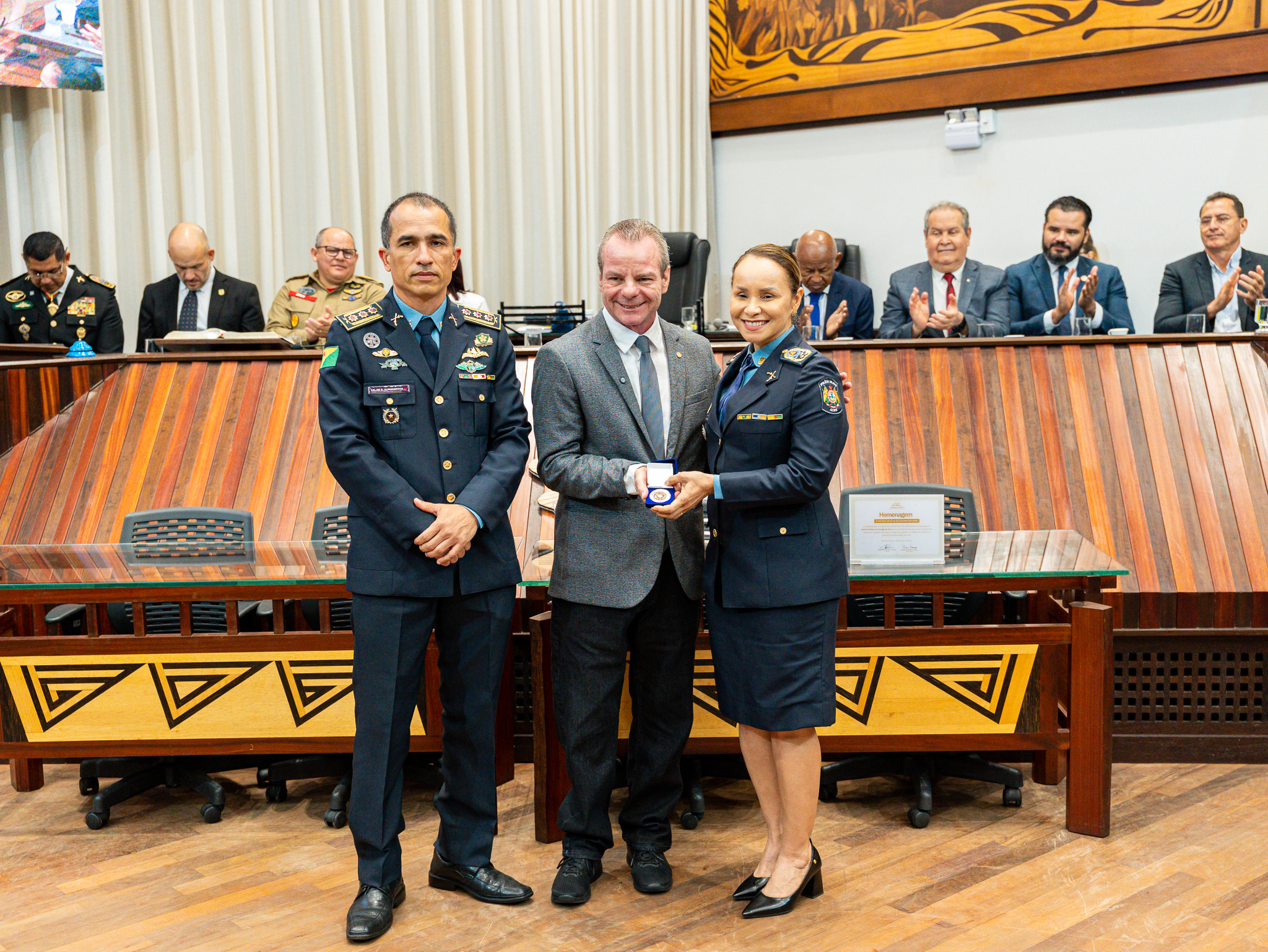 Coronel Marta Renata e coronel Kleison Albuquerque durante entrega da moeda institucional da PMAC. Foto: Davi Silva Barbosa/PMAC.